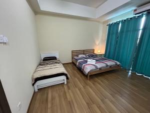 a bedroom with two beds and a wooden floor at Calm Home in Kuala Terengganu in Kuala Terengganu