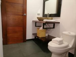 un baño con inodoro y espejo en Scala Inn, en Muelle