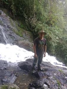 a man standing in front of a waterfall at Sítio lampião do norte in Blinha