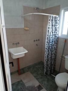 Un baño con lavabo y ducha con inodoro. en comodidad y seguridad, en Ciudad Evita