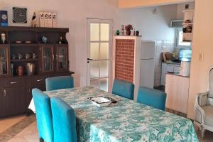 a dining room table with blue chairs and a kitchen at comodidad y seguridad in Cañada de Gómez