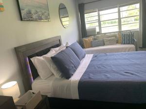 哈兰代尔海滩Walk to the beach, Studio, Pool AND FREE Parking的带一张大床和一张沙发的卧室