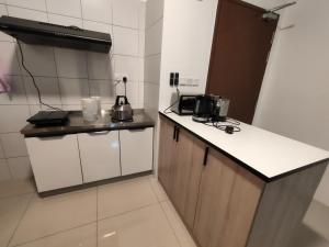 a small kitchen with a counter and a microwave at Jalil homestay by MyPOCKETT in Kampong Bohol