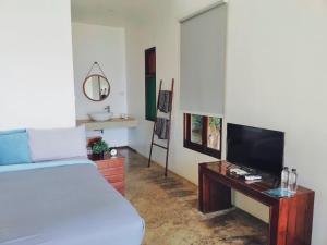 a bedroom with a bed and a table with a television at Villa Allure Koh Mak in Ko Mak