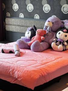 a group of stuffed animals sitting on a bed at Kuromi卡通主题浪漫公寓 配有大屏幕蓝牙音响电影房 Netflix Youtube in Johor Bahru