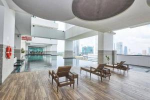 a large room with chairs and a pool in a building at Kuromi卡通主题浪漫公寓 配有大屏幕蓝牙音响电影房 Netflix Youtube in Johor Bahru