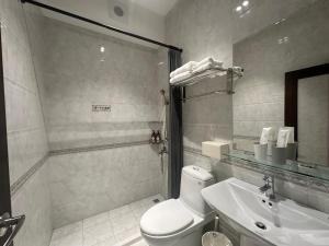 a bathroom with a toilet and a sink and a shower at 金門且停民宿 可包棟 好停車 近市區 in Jinning