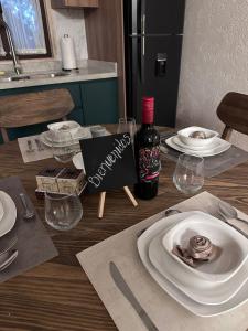 a table with plates of food and a bottle of wine at Apartamento en Valquirico in Tlaxcala de Xicohténcatl