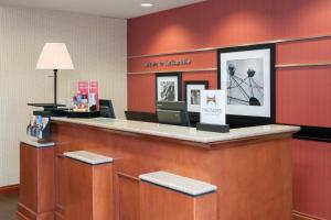 Un vestíbulo de hotel con un mostrador de recepción con paredes rojas. en Hampton Inn Jacksonville, en Jacksonville