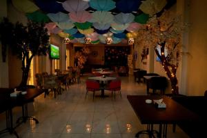 a restaurant with tables and chairs and a ceiling with umbrellas at Jordan View Hotel in Amman