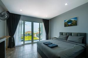 a bedroom with a large bed and a balcony at Reboot Retreat Beach Resort, Restaurant, and Coffee Shop in Ban Talat Bang San +50 photos