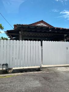 a white fence in front of a house at Alora Homestay in Alor Setar