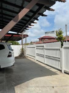 a white fence with a white car parked next to it at Alora Homestay in Alor Setar +4 photos