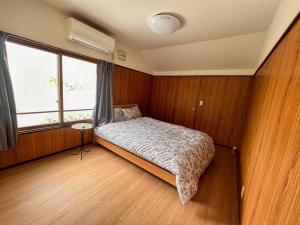 a small bedroom with a bed and a window at Shiro一軒家 in Sapporo