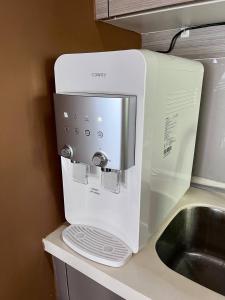 a white microwave sitting on a counter next to a sink at Emira Residence Seksyen 13 Shah Alam by Alpha LaVista in Shah Alam