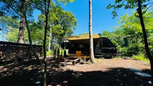 御代田町RK nomadic的树林里的小屋，有帐篷和野餐桌