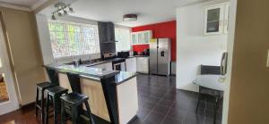 a kitchen with a counter and stools in it at Bohemian Lodge - Artist's Boutique in Kingston