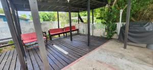 a porch with two red benches on a wooden deck at Bohemian Lodge - Artist's Boutique in Kingston