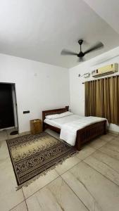 a bedroom with a bed and a ceiling fan at Traditional house near Kochi in Cochin