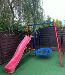 a playground with a red slide and a swing at Apartamenty NAUTICA Rowy, 150m od plaży in Rowy +20 photos