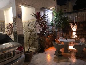 a patio with a table and chairs at night at Casarão historico in Recife