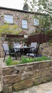 a patio with two chairs and a table in front of a building at Commerce Cottage Rooms in Ripley