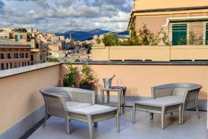 a balcony with chairs and a table with a view at Meliá Genova in Genoa