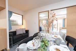 神户CASA Kobe 1st floor的客厅里有一张桌子和一张沙发