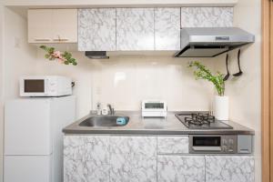 a kitchen with a sink and a refrigerator at CASA Kobe 1st floor in Kobe +13 photos
