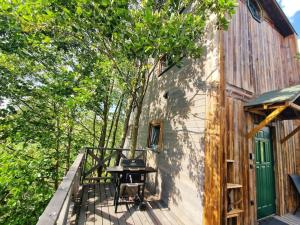 a wooden deck with a table next to a building at Domek w drzewach Ostoja in Krzesimów