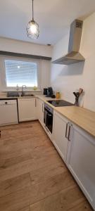a kitchen with white cabinets and a counter top at L'Escapade du Bonheur, 4 pers, nature alsacienne et parking in Gundershoffen