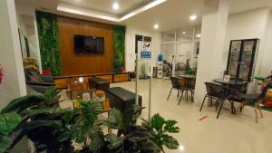a living room with plants and a tv on a wall at P Bliss hotel in Phayao
