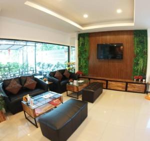 a living room with couches and a flat screen tv at P Bliss hotel in Phayao