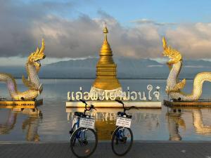two bikes parked in front of a pagoda in the water at P Bliss hotel in Phayao