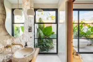 a bathroom with a sink and a large window at Alma Bingin Boutique Hotel in Uluwatu
