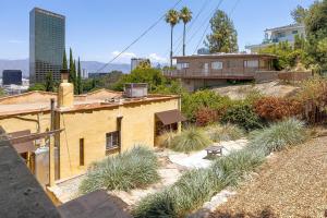 Una casa amarilla con algo de hierba alta en una colina. en Hollywood Hills Walk to Universal City Views, en Los Ángeles
