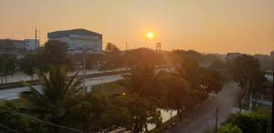 a sunset over a city with palm trees and a street at P Bliss hotel in Phayao