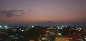 a city at night with a mountain in the background at P Bliss hotel in Phayao