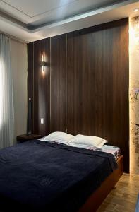 a bedroom with a bed with a wooden headboard at Mộc Trà Hotel in Ho Chi Minh City