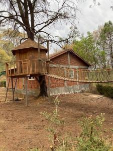 a tree house in front of a brick building at Hermosa Cabaña en bosque muy cerca Patzcuaro in Tupátaro
