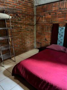 a bedroom with a brick wall and a red bed at Hermosa Cabaña en bosque muy cerca Patzcuaro in Tupátaro +24 photos