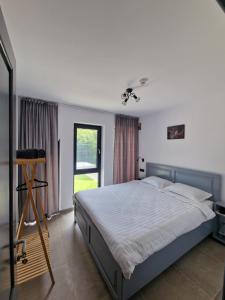 een slaapkamer met een groot bed en een raam bij Hidden Chalet in Tarcău-Gheuca +27 foto's