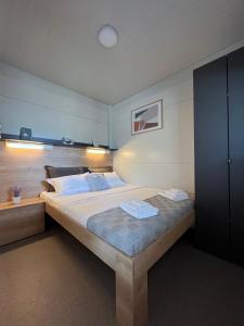 a bedroom with a large bed with two towels on it at Vi&No Mobile Home - Camping Pirovac in Pirovac