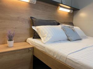 a bed with white sheets and pillows in a room at Vi&No Mobile Home - Camping Pirovac in Pirovac +50 photos