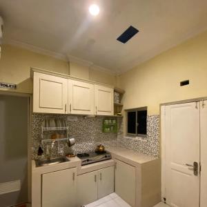 a kitchen with white cabinets and a sink at Kedyla Homestay Syariah in Ngabean