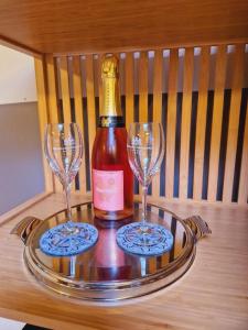 a bottle of wine and two wine glasses on a tray at Gîte Le Sambre in Thuin