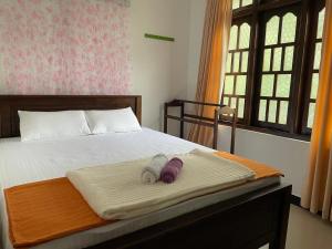 a bedroom with a bed with two towels on it at Ella Peaks Lodge in Ella