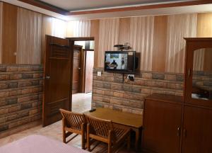 a room with a table and a tv on a brick wall at Hotel Sunrise in Chandīgarh +19 photos