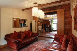 a living room with a leather couch and a brick wall at Tonge Barn in Sittingbourne