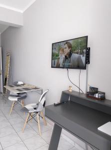a living room with a tv on a wall at SWEET APPARTMENT in Patra